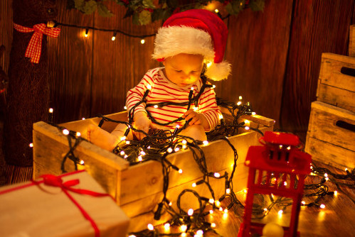 Child wrapped up in xmas lights