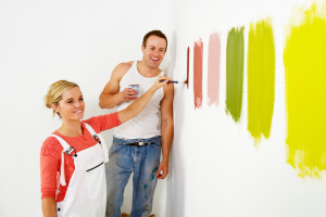 Woman painting colour swatches on wall