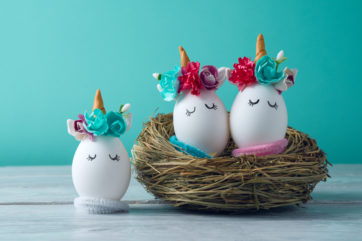 unicorn decorated eggs sat in nest