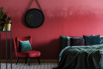 dark red and green bedroom interiors with hanging mirror and indoor plants