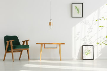 Light space with frames, natural wooden furniture and low-hanging light