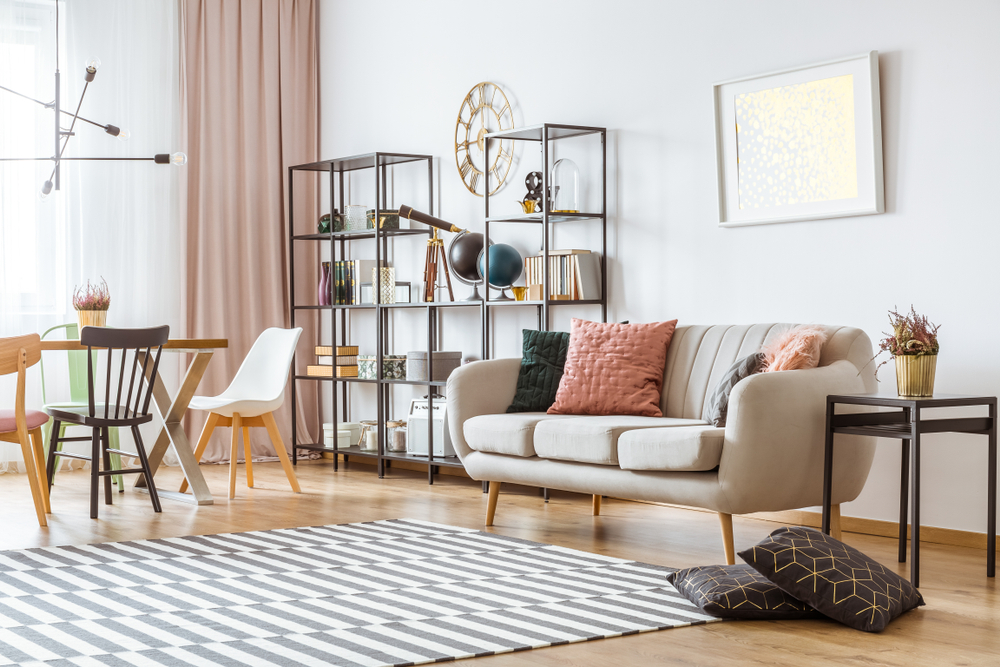 Picture Frames On White Wall Above Sofa With Cushions In Living Room