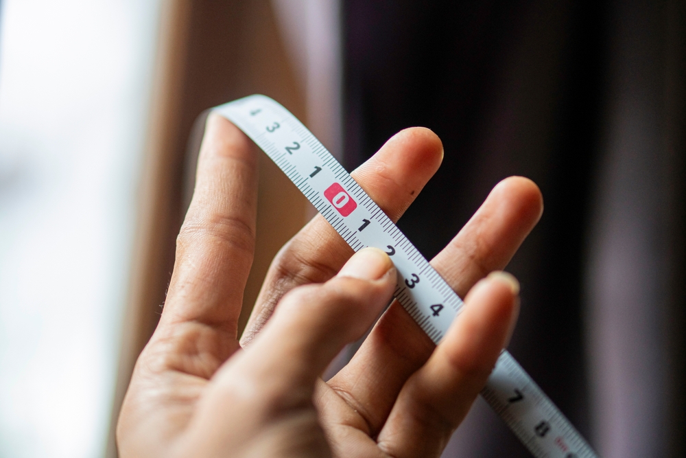 close up of hand holding measuring tape