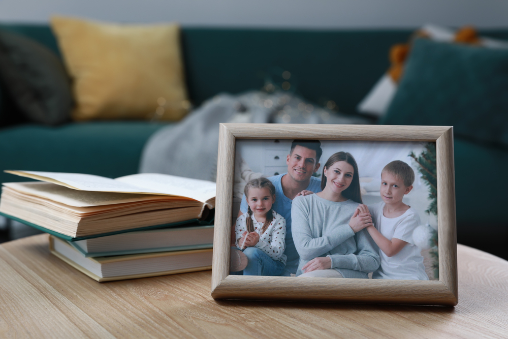 Framed family photo and books on wooden table